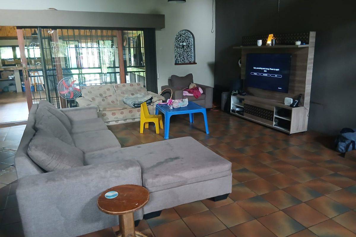 Spacious living room featuring tiled flooring, high ceilings, and large sliding glass doors providing access to the patio area.