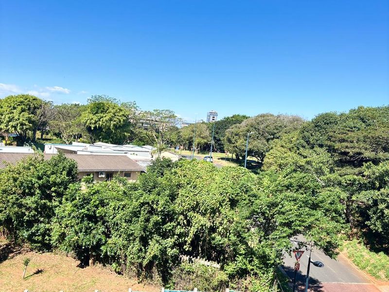Elevated view overlooking the surrounding neighbourhood, mature trees, and local street infrastructure.