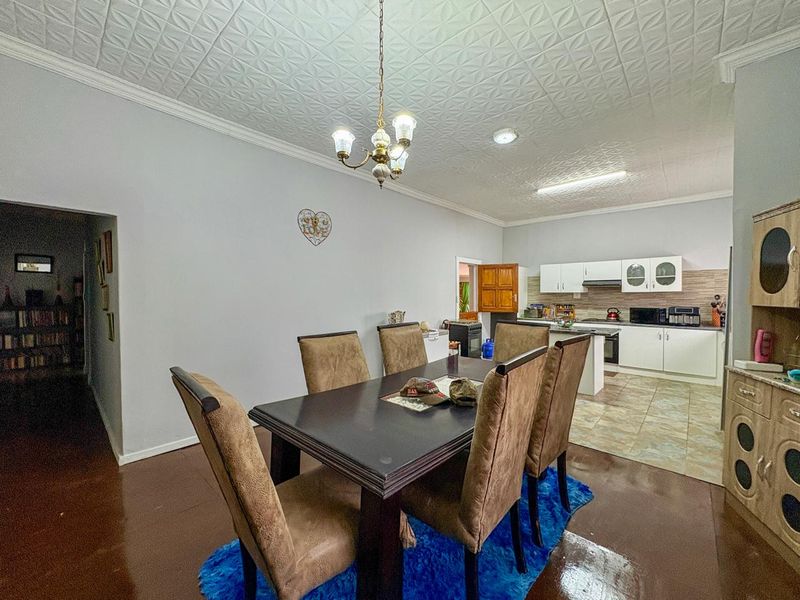 Open plan dining and kitchen area featuring tiled kitchen flooring, built-in cabinetry, and a decorative ceiling finish.