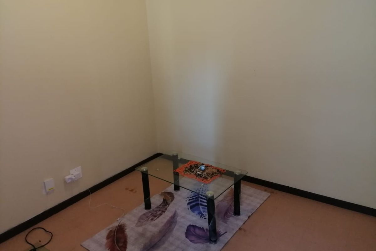 A sparse, empty room featuring plain walls and flooring, suitable for use as a bedroom or living area.
