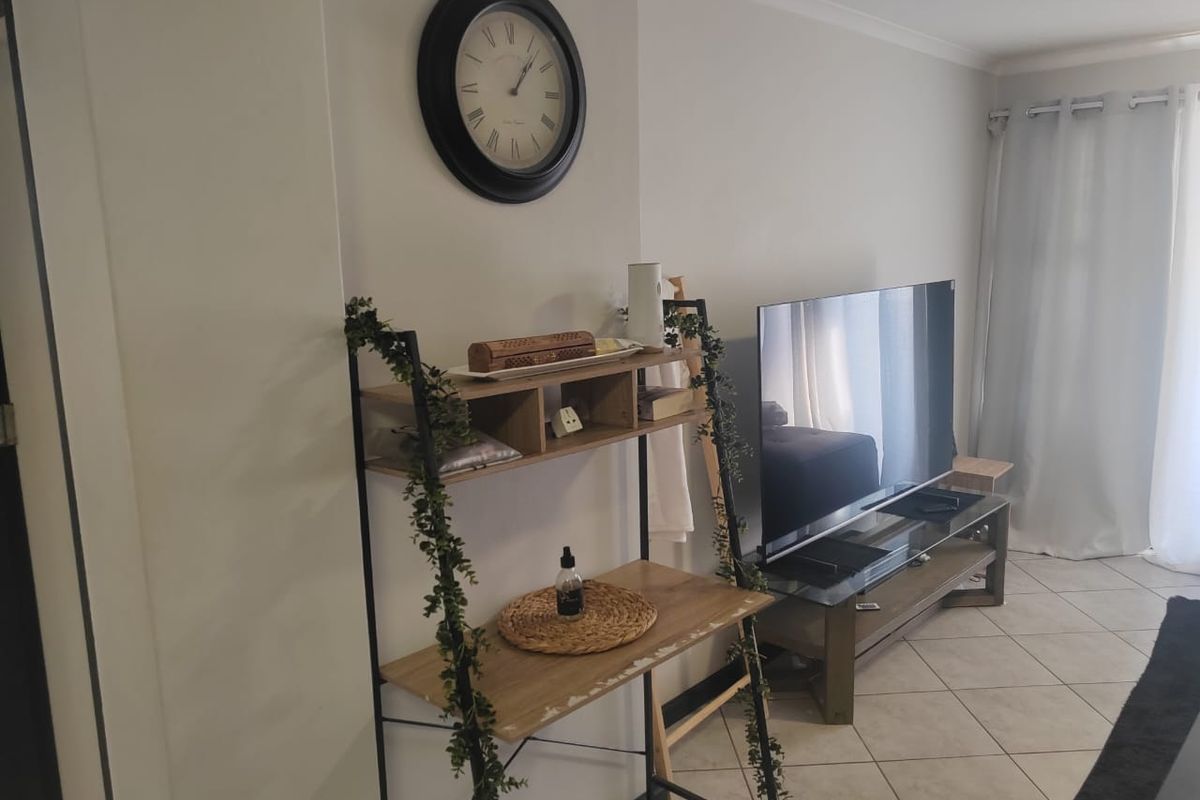 A living room area featuring tiled flooring and neutral wall finishes, providing a functional space for relaxation and entertainment.
