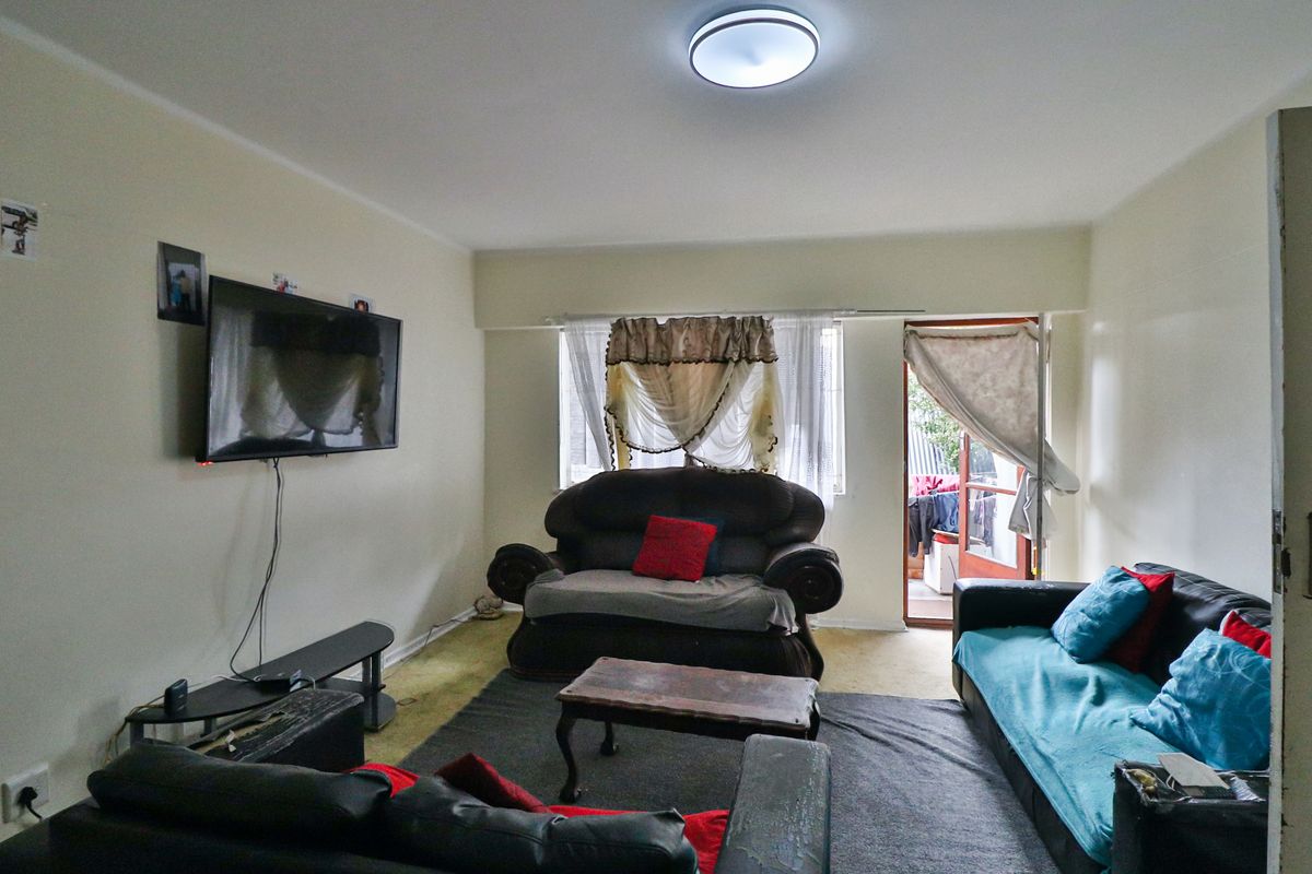 A living room featuring carpet flooring, a ceiling-mounted light fixture, and direct access to an outdoor balcony area.