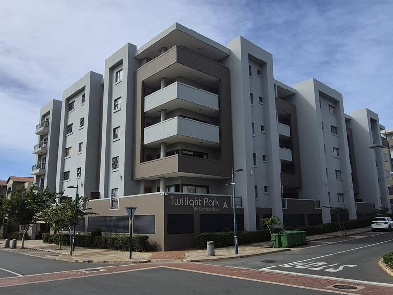 Exterior view of the Twilight Park apartment complex, showcasing its modern multi-story facade, balconies, and street-level entrance.