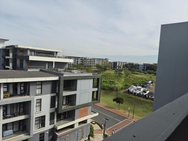 Elevated view overlooking the surrounding apartment complex, landscaped green space, and nearby street infrastructure.
