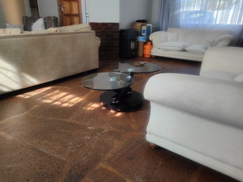 A living room featuring rustic flagstone flooring and a brick feature wall, providing a textured foundation for the living space.