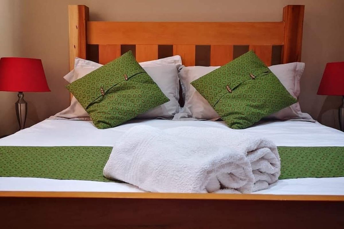 A bedroom featuring a solid timber bed frame, providing a warm and classic aesthetic to the sleeping space.