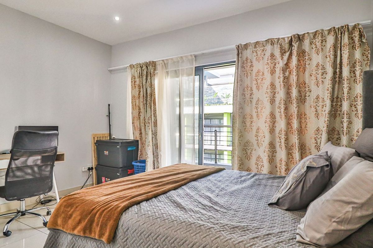 A bedroom featuring tiled flooring, recessed ceiling lighting, and a sliding glass door providing access to a balcony.