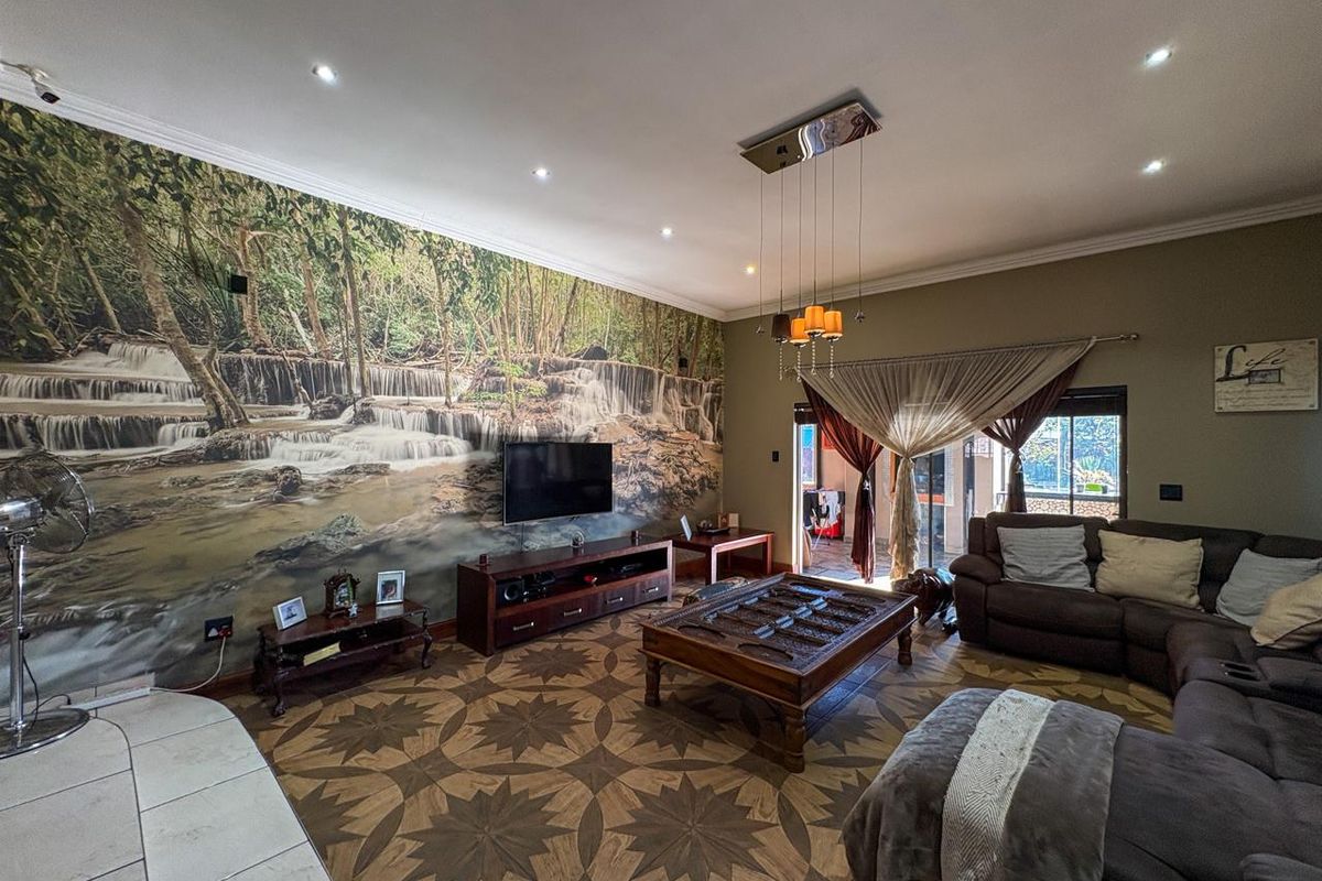 Spacious living room featuring decorative patterned floor tiles, recessed lighting, and a prominent nature-themed wall mural, creating a unique focal point.