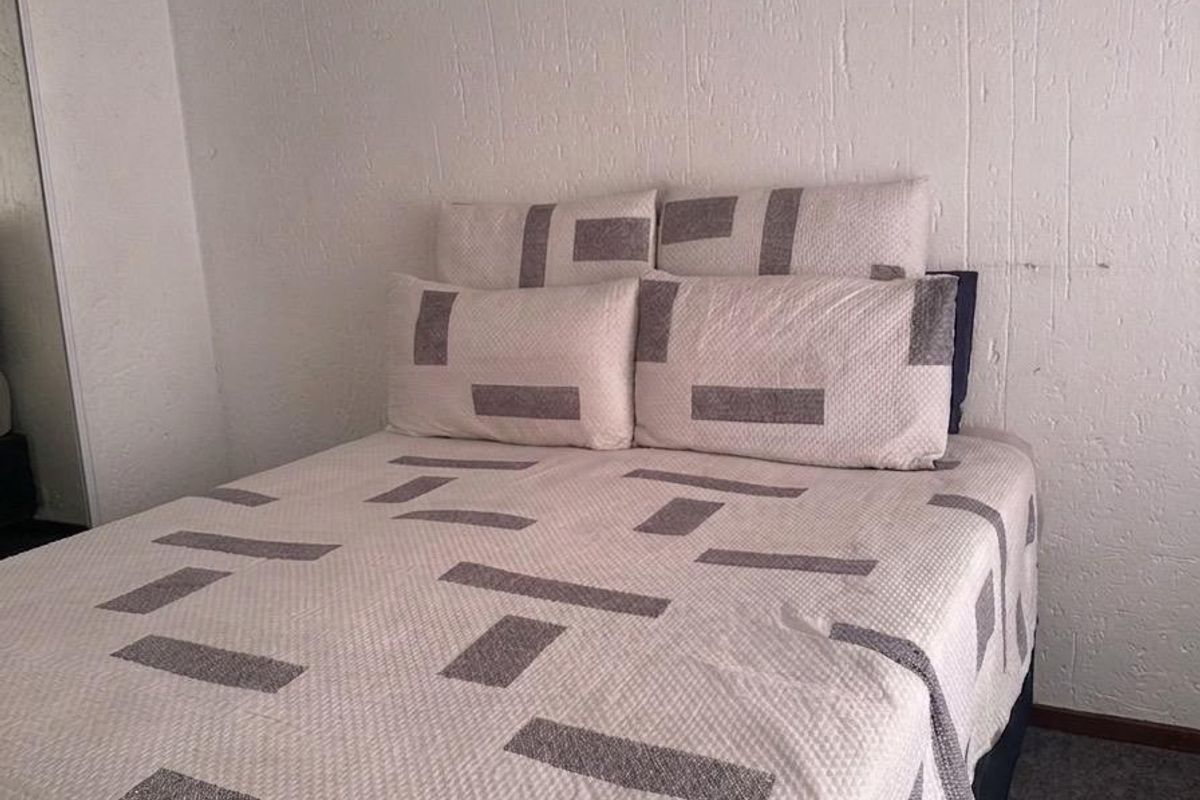 A bedroom featuring textured walls and built-in storage, requiring cosmetic updates to improve the overall finish and appeal.