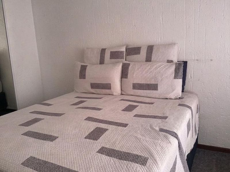 A bedroom featuring textured walls and built-in storage, requiring cosmetic updates to improve the overall finish and appeal.