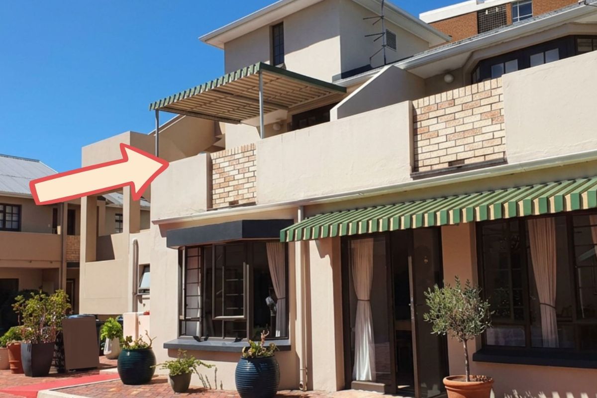 Exterior view of a retirement village unit featuring a ground floor patio and an upper-level balcony with a fixed awning.
