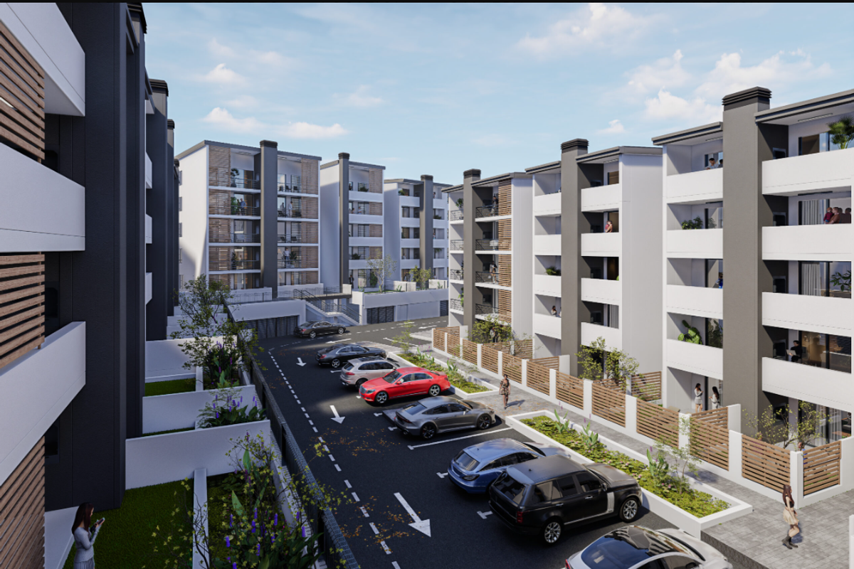 A modern apartment complex development featuring multi-story residential blocks, paved parking areas, and landscaped surroundings.