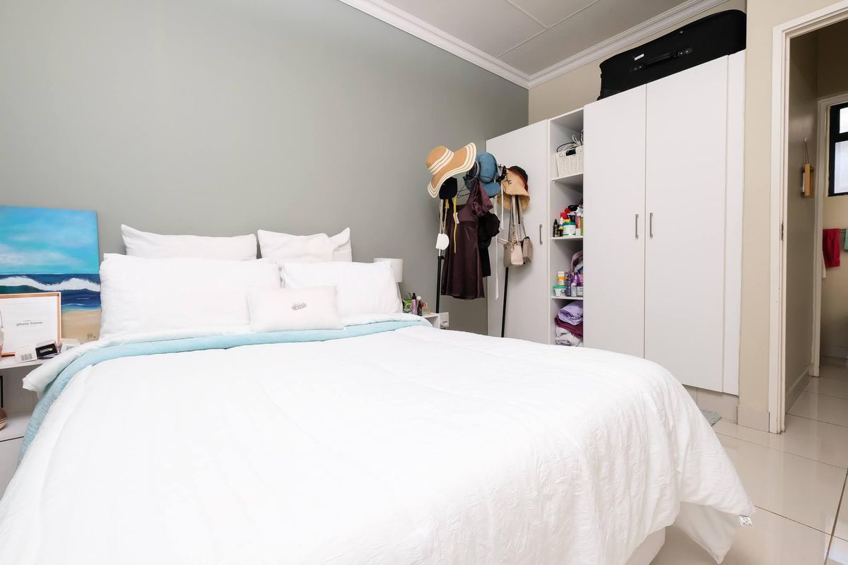 A well-maintained bedroom featuring built-in white cabinetry and neutral wall finishes, providing a clean and functional living space.