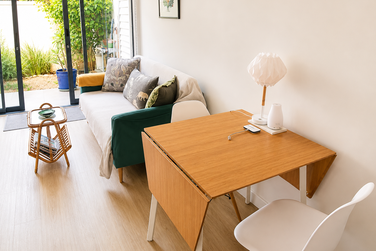 A bright living area featuring light wood-look flooring and large sliding glass doors that provide seamless access to the outdoor patio and garden.