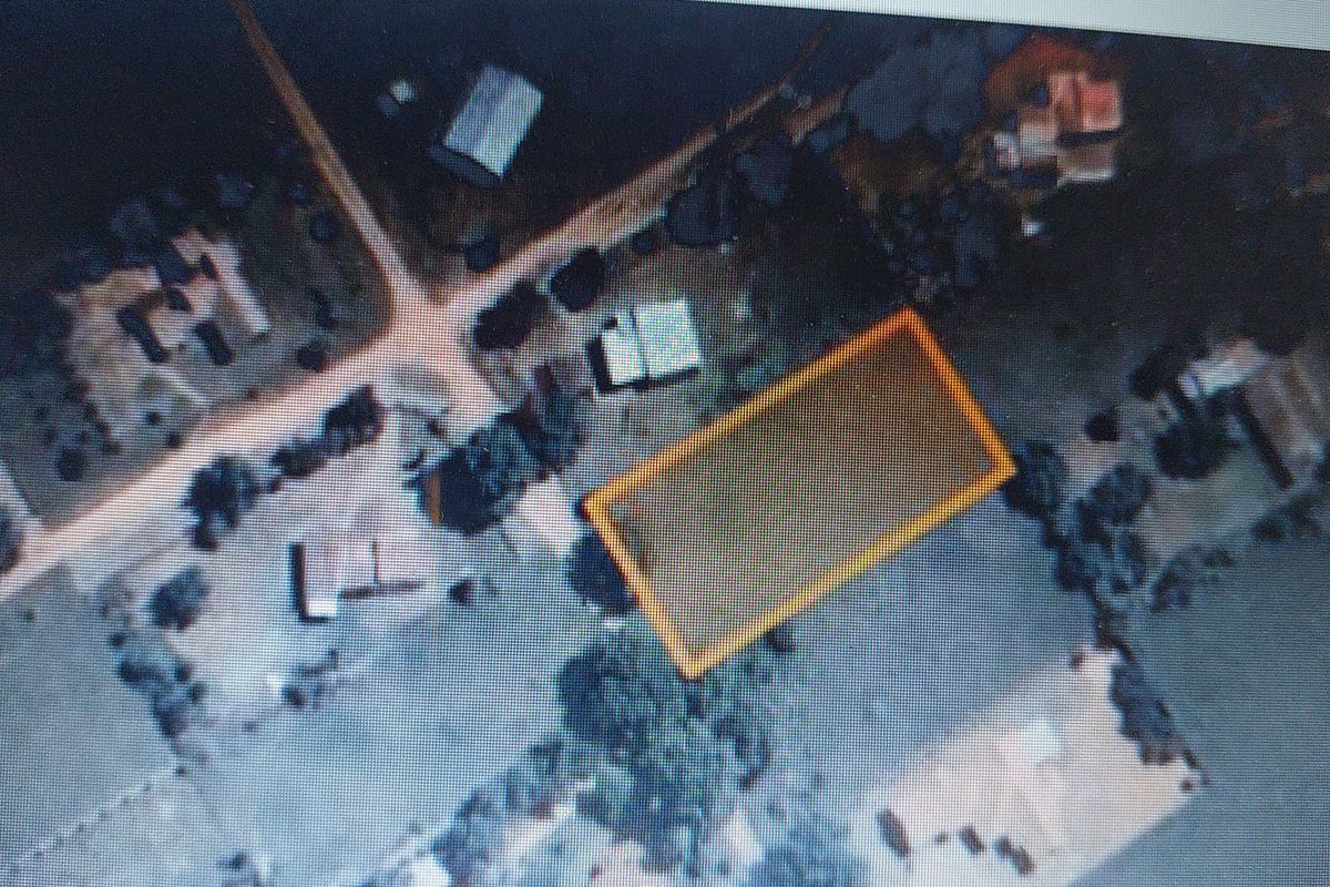 An aerial view of a vacant residential plot highlighted in yellow, showing the surrounding neighborhood and land layout.