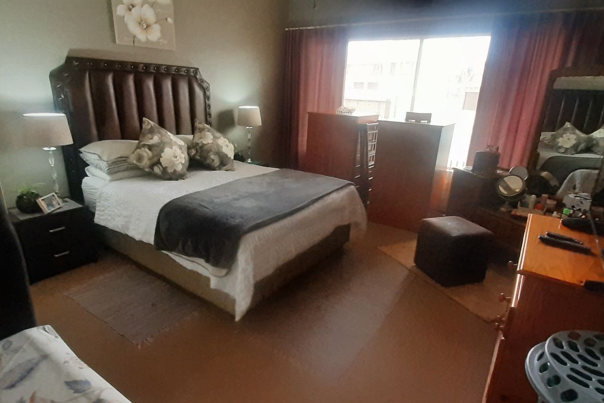 A well-proportioned bedroom featuring large windows that provide natural light, neutral wall finishes, and durable flooring.