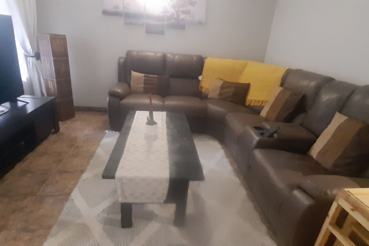 A comfortable living room featuring tiled flooring and neutral wall finishes, providing a functional space for relaxation.