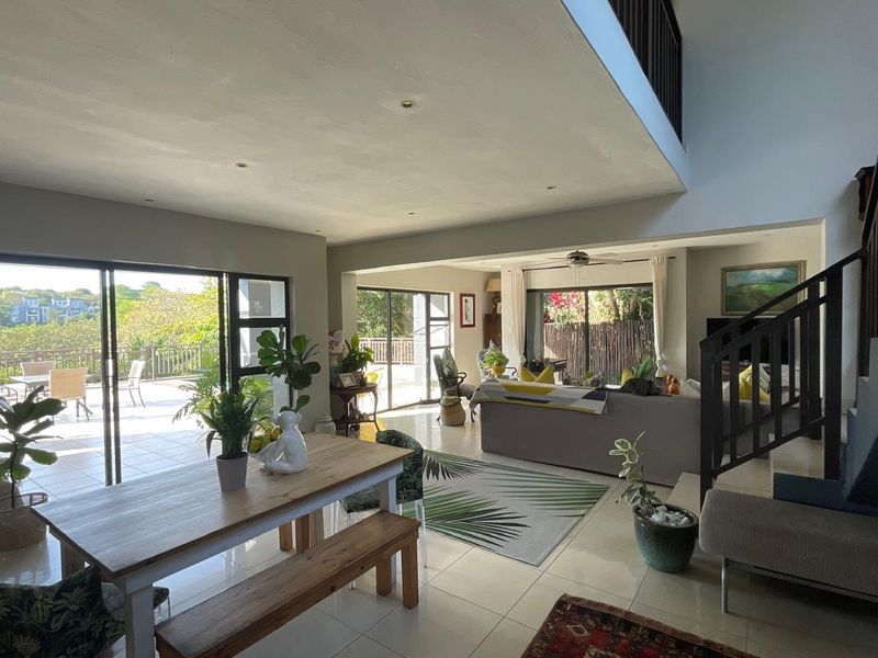 Spacious open-plan living and dining area featuring large sliding glass doors that provide seamless access to an outdoor patio and garden.