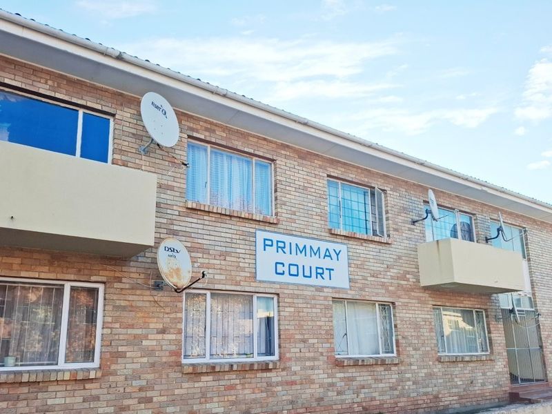 Exterior view of Primmay Court apartment building featuring a face brick facade, balconies, and security gates.