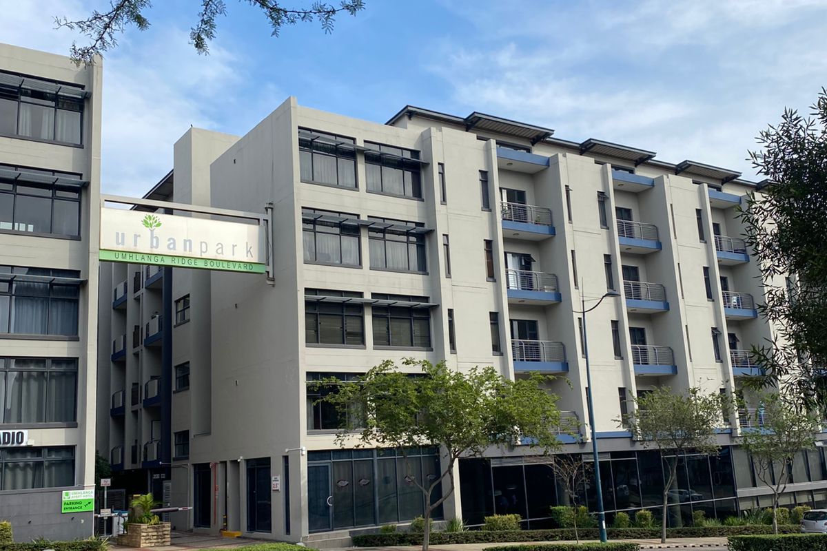 Exterior view of the Urban Park apartment complex, featuring modern multi-story architecture with balconies and street-level commercial frontage.