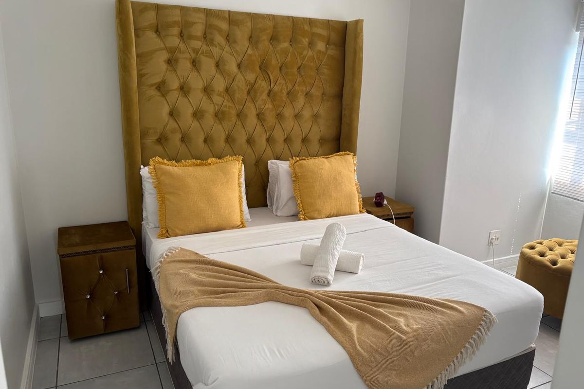 A well-maintained bedroom featuring tiled flooring and a neutral color palette, providing a clean and comfortable living space.