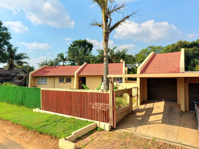 Front view of a single-story residence featuring a tiled roof, attached garage, and gated entrance with a private driveway.