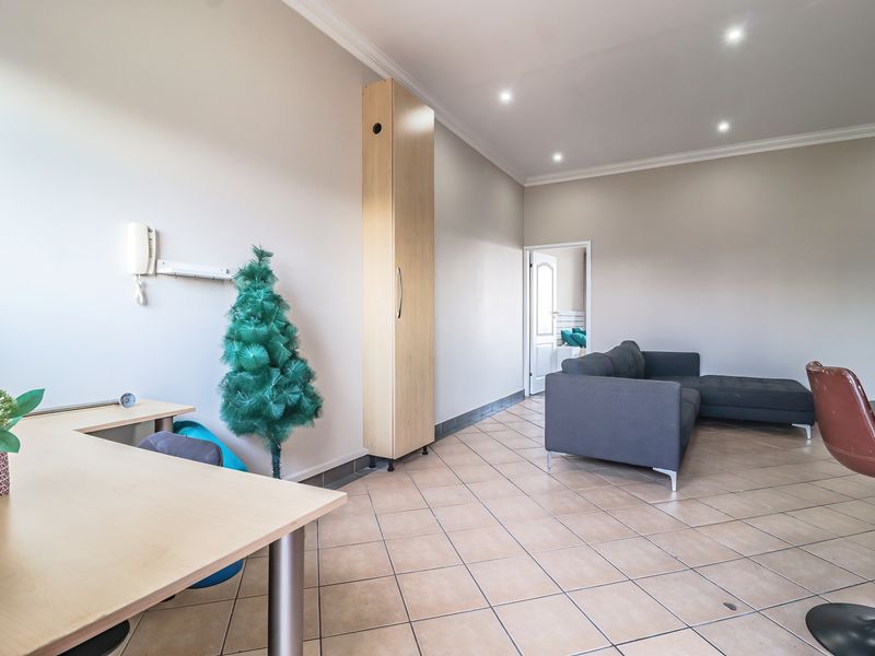 Spacious living area featuring tiled flooring, recessed downlighting, and a built-in storage cabinet, offering a versatile layout for comfortable living.