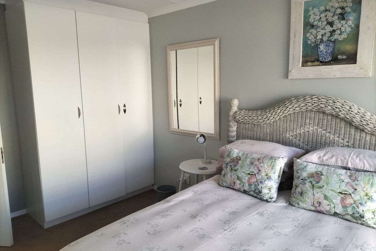 A bedroom featuring built-in white cabinetry and neutral wall tones, providing a functional and tidy sleeping space.
