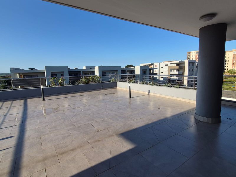Spacious open-air balcony featuring modern tiled flooring, stainless steel railings, and integrated lighting, offering an expansive outdoor area for relaxation.