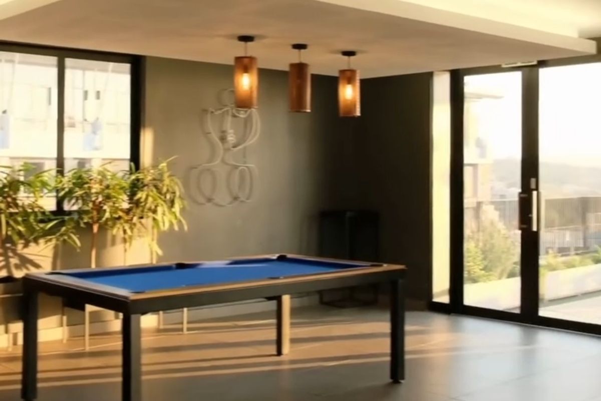 Modern living area featuring large format floor tiles, recessed ceiling lighting, and expansive sliding glass doors leading to an outdoor space.