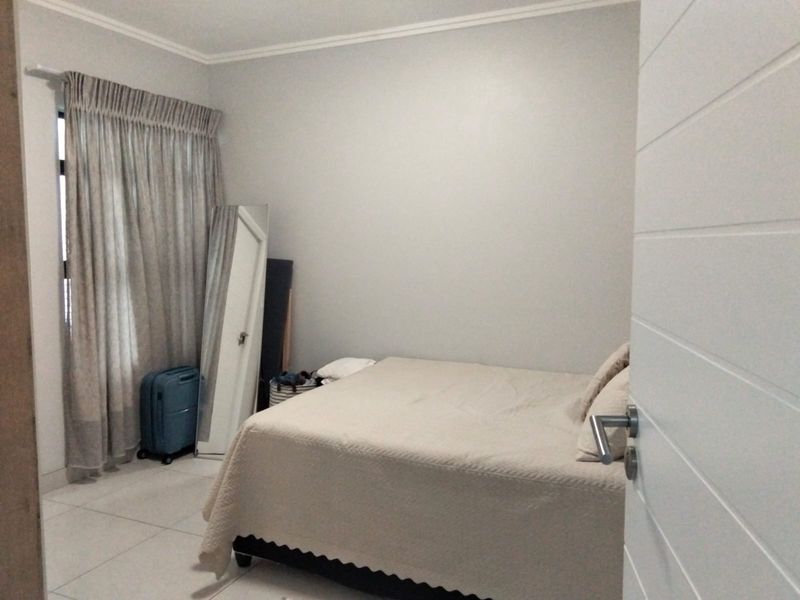 A bedroom featuring tiled flooring, neutral wall finishes, and a window with curtain tracks.