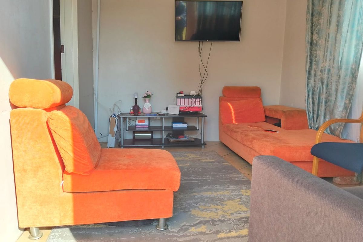 A living room area featuring tiled flooring and wall-mounted television connectivity.