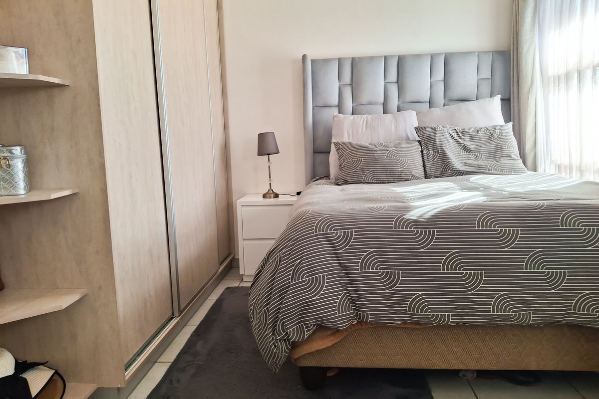 A well-maintained bedroom featuring a built-in wardrobe and tiled flooring, offering a clean and functional living space.