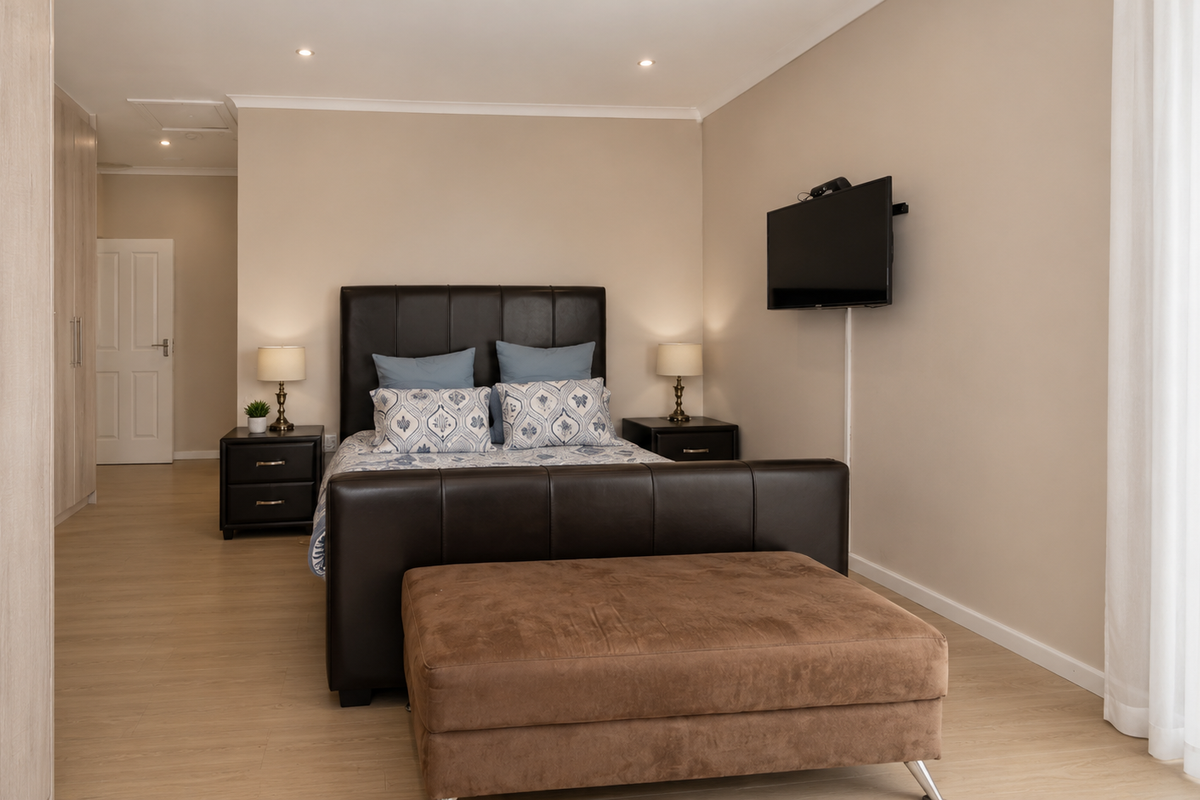 A well-maintained bedroom featuring light wood-look flooring, built-in cabinetry, and neutral wall tones, creating a clean and comfortable living space.