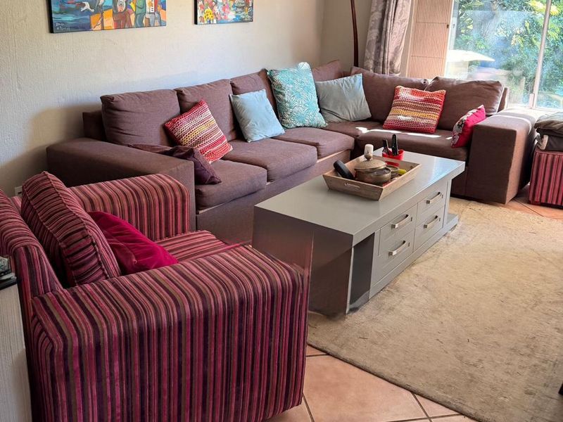 A comfortable living room featuring tiled flooring and large sliding glass doors that provide natural light and access to the outdoor area.