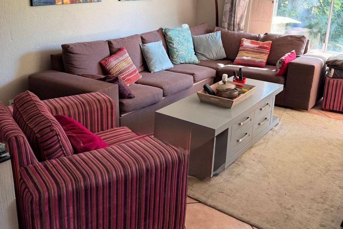 A comfortable living room featuring tiled flooring and large sliding glass doors that provide natural light and access to the outdoor area.
