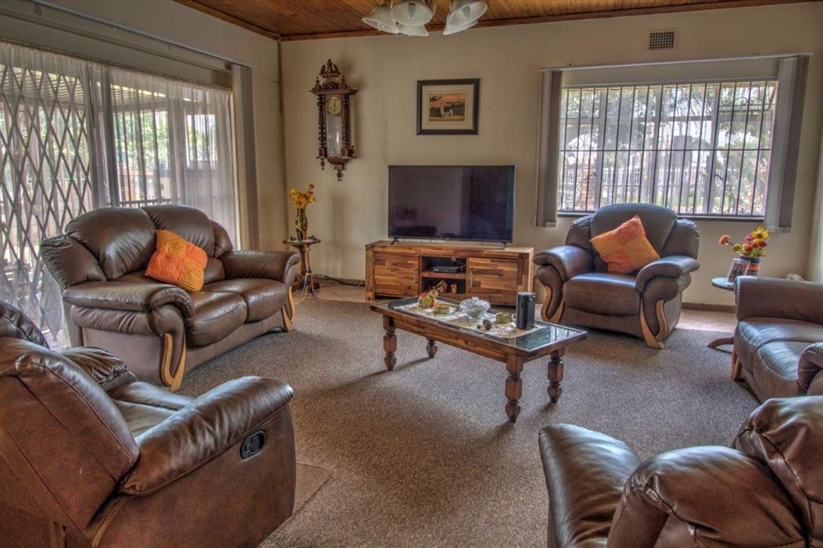 A living room featuring a timber ceiling, carpeted flooring, and security bars on the windows.