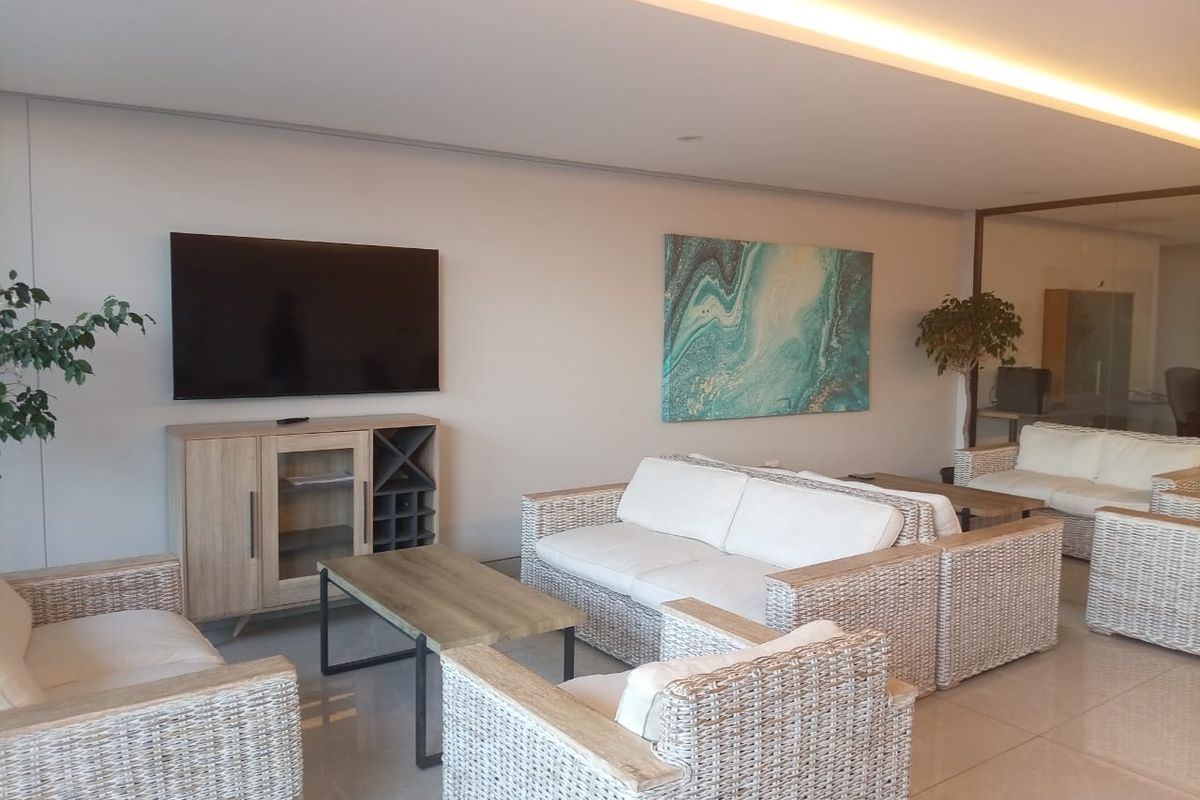 A bright and spacious living area featuring recessed ceiling lighting and polished tile flooring, creating a modern and comfortable atmosphere.