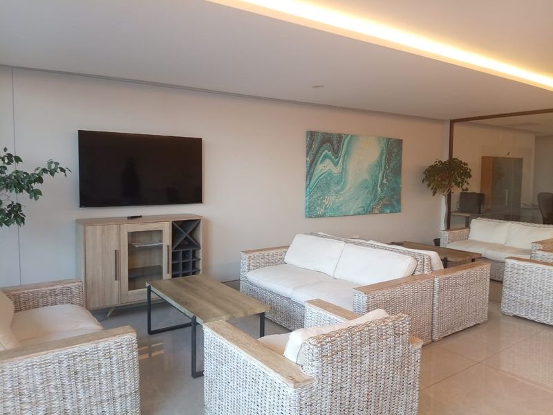 A bright and spacious living area featuring recessed ceiling lighting and polished tile flooring, creating a modern and comfortable atmosphere.