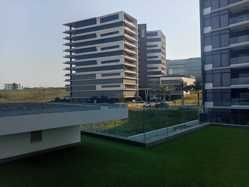 View of modern high-rise apartment buildings and landscaped grounds from an elevated perspective.