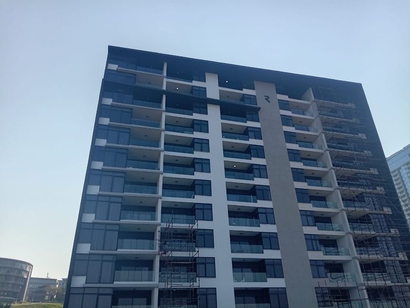 Modern high-rise apartment building exterior featuring glass balconies and contemporary architectural design.