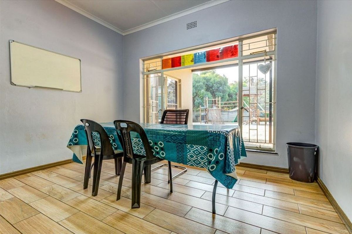 A functional living space featuring wood-look tiled flooring and large sliding doors providing direct access to the rear garden area.