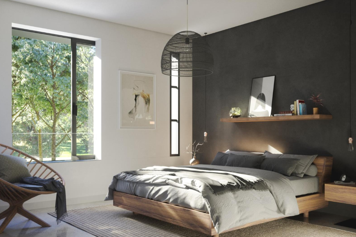A modern, well-lit bedroom featuring a dark accent wall, large windows with natural views, and a minimalist floating wooden shelf.