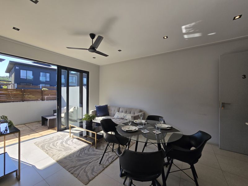 Open-plan living and dining area featuring tiled flooring, recessed ceiling lighting, a modern ceiling fan, and large sliding glass doors leading to a private balcony.