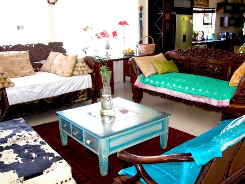 An open-plan living area featuring tiled flooring and a view into the adjacent kitchen space.