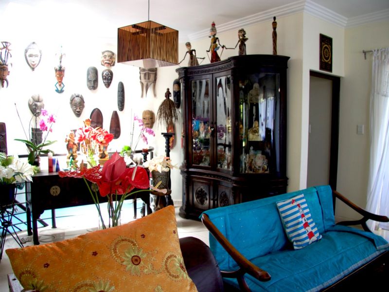 A living room area featuring crown molding, tiled flooring, and a neutral wall finish.