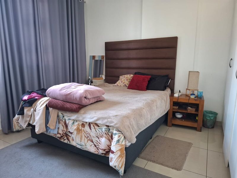 A functional bedroom featuring tiled flooring and a built-in wardrobe, offering a neutral base for personalization.