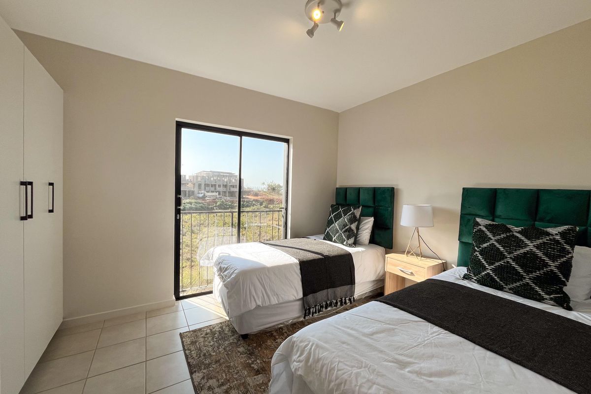 A well-lit bedroom featuring tiled flooring, a built-in wardrobe, and a sliding glass door providing access to an outdoor view.