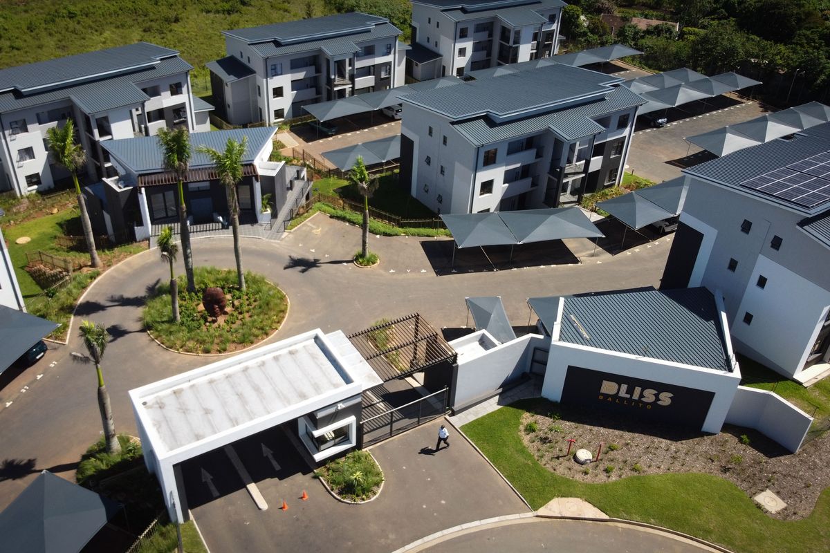 Aerial view of the Bliss Ballito apartment complex, featuring modern multi-story residential blocks, secure gated entrance, covered parking, and well-maintained landscaped grounds.
