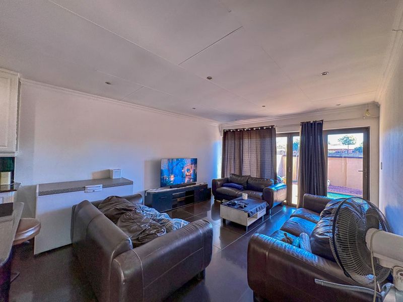 Open plan living area featuring tiled floors, recessed lighting, and sliding glass doors providing access to the outdoor patio area.